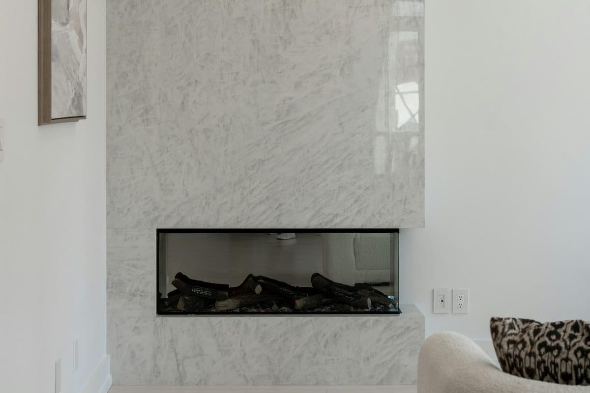 Modern white marble slab fireplace surround with a linear firebox